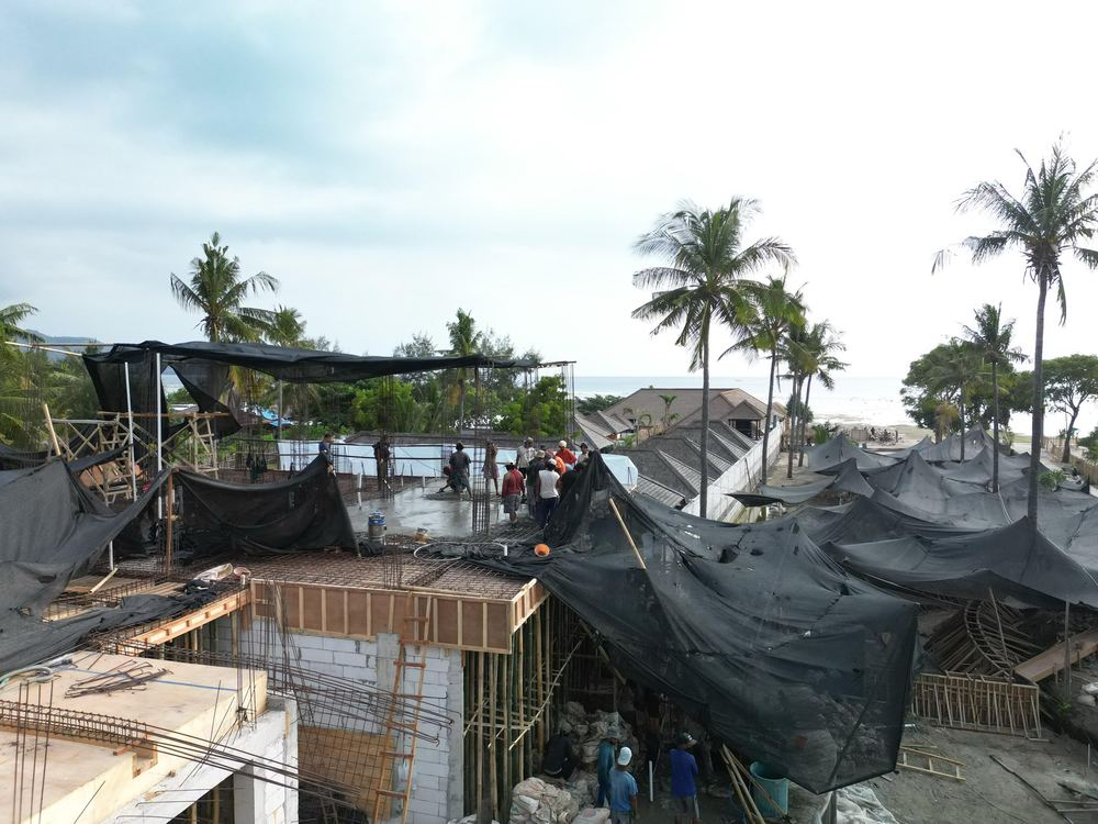 Concrete pool basins under construction at Divino Beach Gili Air, shaded by netting