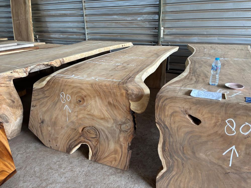 Live-edge suar wood slabs marked and prepared at the Divino Art workshop in Indonesia